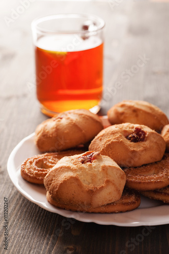 Cookies on a white plate with cup of tea