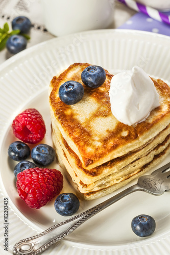 Stack of heart shaped pancakes with fresh berries