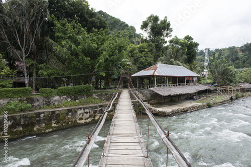 Puente de madera sobre río en un pequeño pueblo en la jungla de de Sumatra, Indonesia