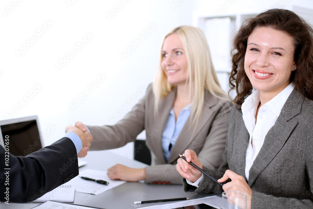 A group of business people at a meeting on the background of office. Business handshake A group of business people at a meeting on the background of office. Business handshake