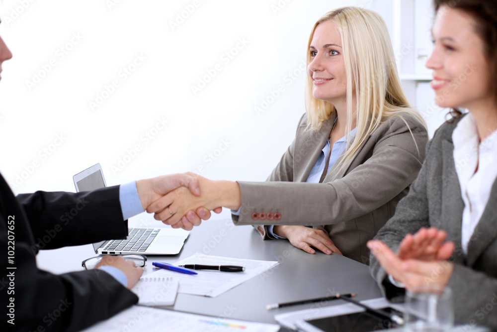 © rogerphoto - A group of business people at a meeting on the background of office. Business handshake. Focus on a beautiful blonde © rogerphoto - A group of business people at a meeting on the background of office. Business handshake. Focus on a beautiful blonde