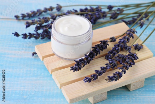 Jar of cream and dried lavender flowers. Herbal beauty treatment.