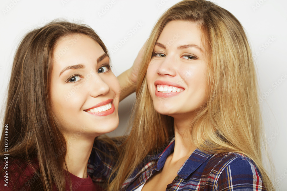 Two young girl friends standing together and having fun. 