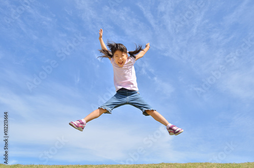 青空でジャンプする女の子