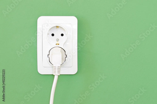 European white electrical outlet socket and white cable pluged i