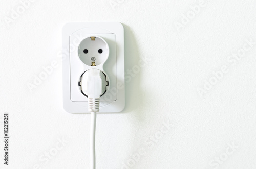 European white electrical outlet socket pluged in on white wall photo