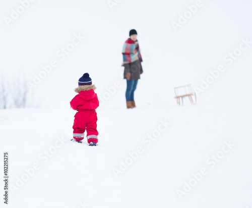 Boy and his mother playing in winter landscape. Child model