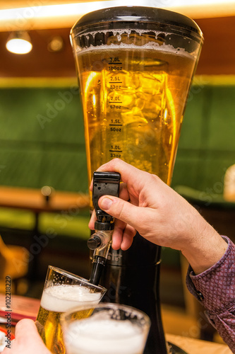 Beer crane in the club. Beer is poured into a glass from a three-liter container with tap