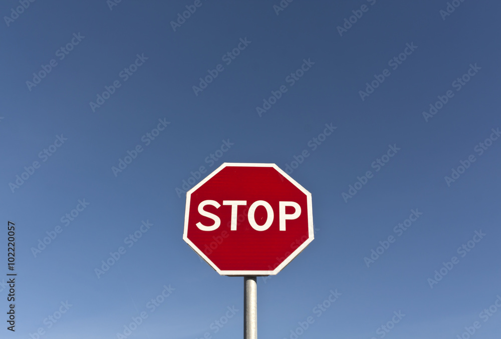 Red stop sign and blue sky.