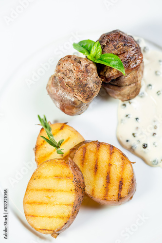 Beautiful juicy grilled meat with fried potatoes on a wooden table