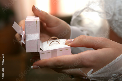 bride holds a box with gold wedding rings close up