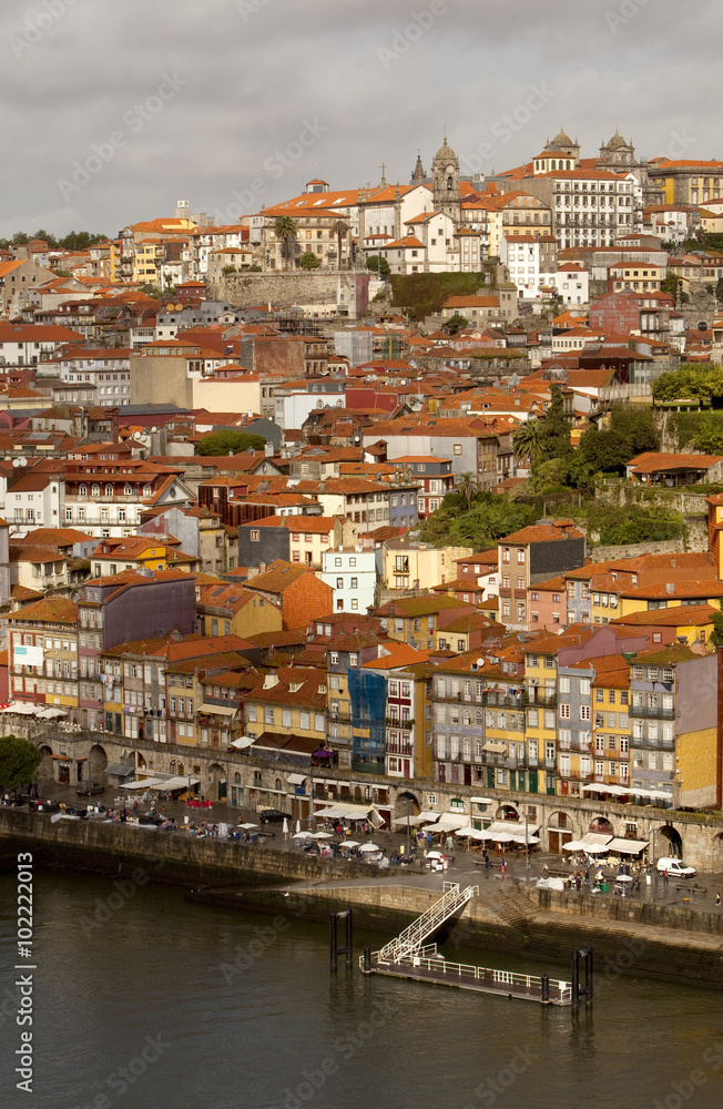 Porto runs down a Steep River Bank. The river Douro has cut a deep river path through the landscape where Porto the historical town has been built. Porto cascades down these steep river banks.
