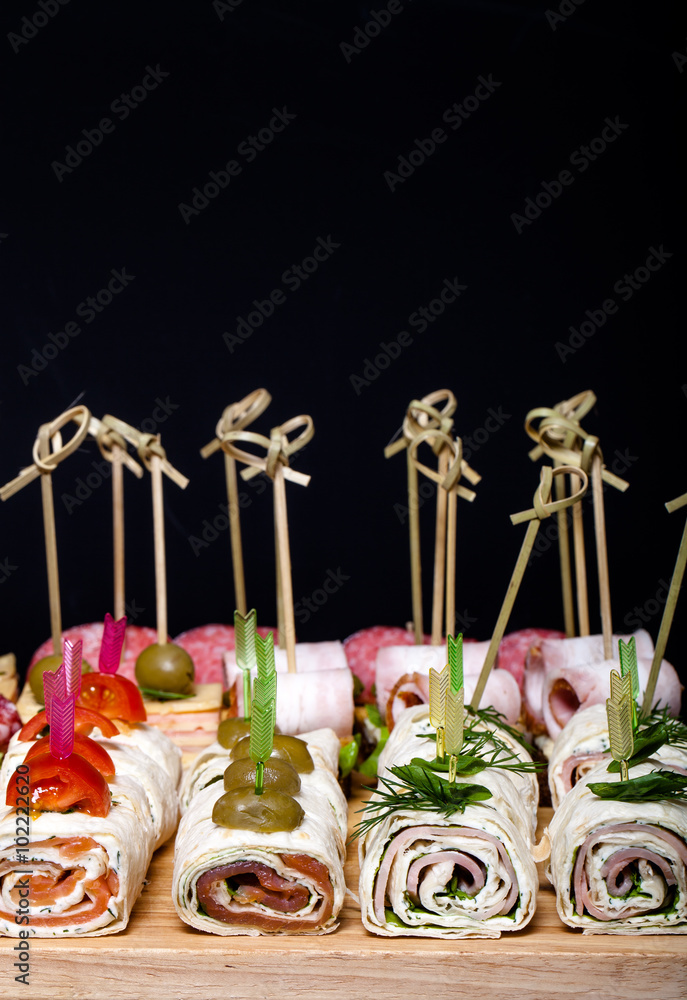 Different kinds of snacks canape on skewers. Shallow depth of fi