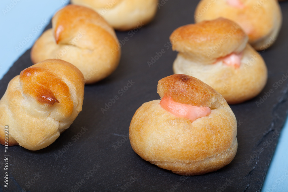 Set of small profiteroles on a black slate plate. Shallow depth Set of small profiteroles on a black slate plate. Shallow depth