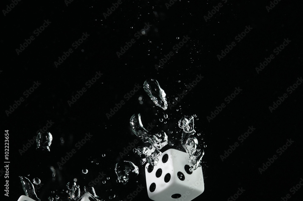 Fototapeta premium Dice falling into water. On a black background.