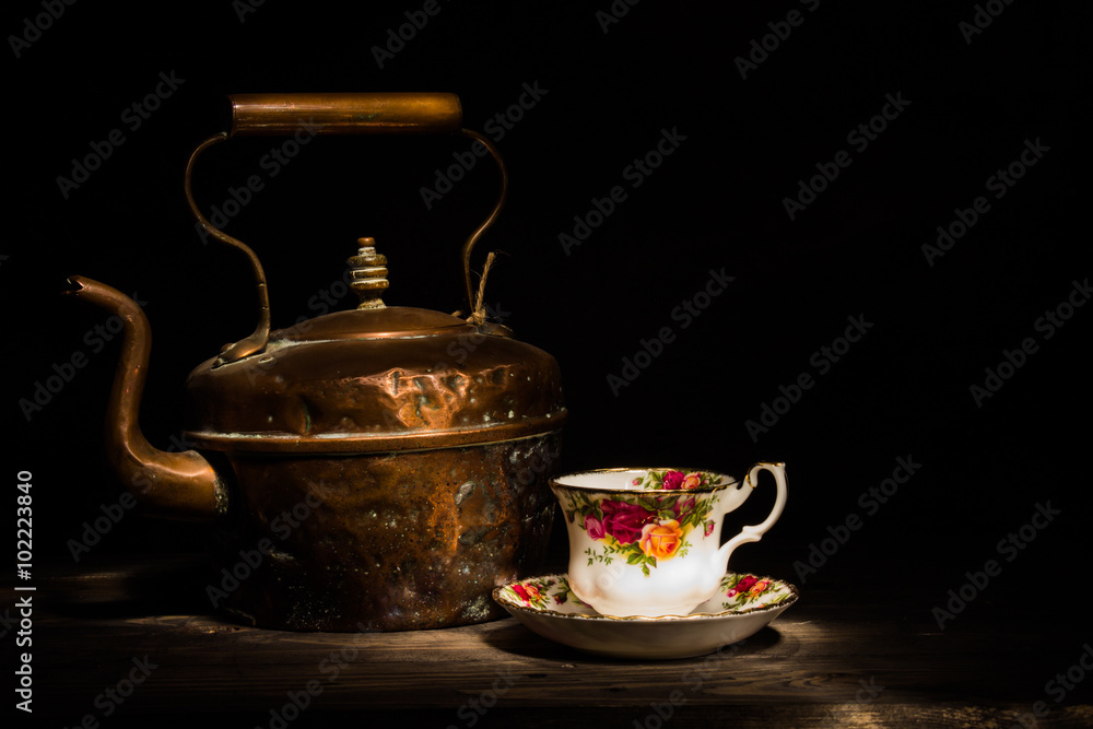Old copper kettle and Roses china teacup Old copper kettle and Roses china teacup
