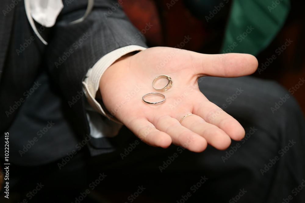 gold rings for wedding are on the palm of the groom