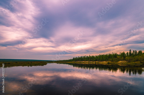 Summer landscape with river, forest and clouds on the blue sky 