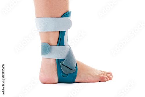 Man Wearing Ankle Support Brace in White Studio. photo