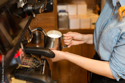 close up of woman making coffee by machine at cafe