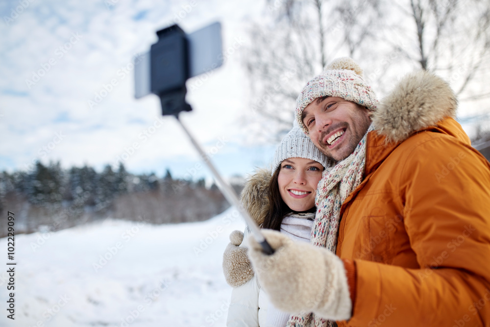 happy couple taking selfie by smartphone in winter happy couple taking selfie by smartphone in winter