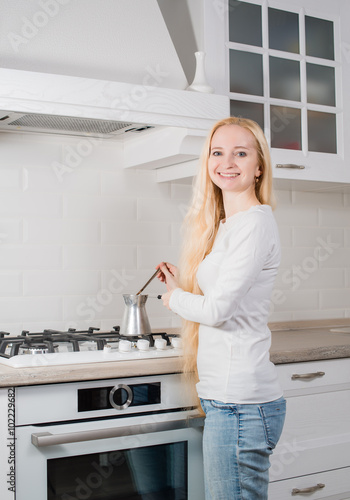 young blonde girl make coffee in сezve
