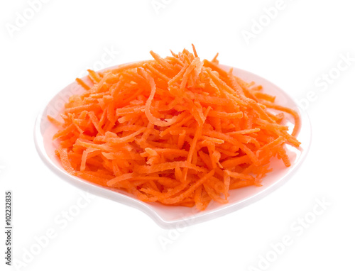 Carrot on a white plate on a white background. Isolated object.