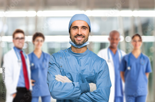 Smiling surgeon in front of his team photo
