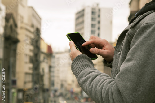 Man using cellphone outdoors.