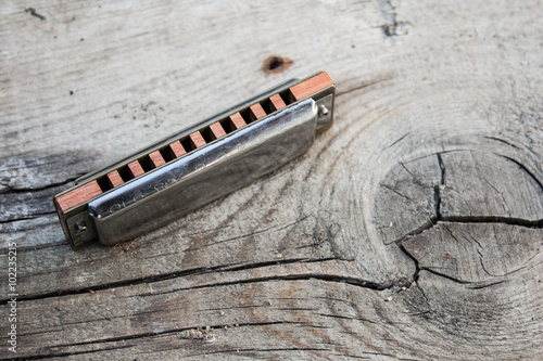 Fotografie Blues harmonica on a wooden background