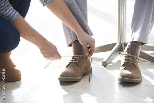 Fotografía Adult Daughter Helping Senior Tie Shoelaces