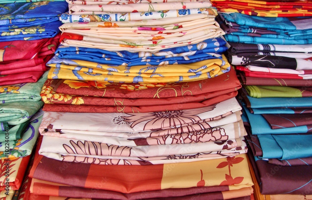 Selection of colourful oilcloths, stacked on a french, local market, Provence, France Selection of colourful oilcloths, stacked on a french, local market, Provence, France