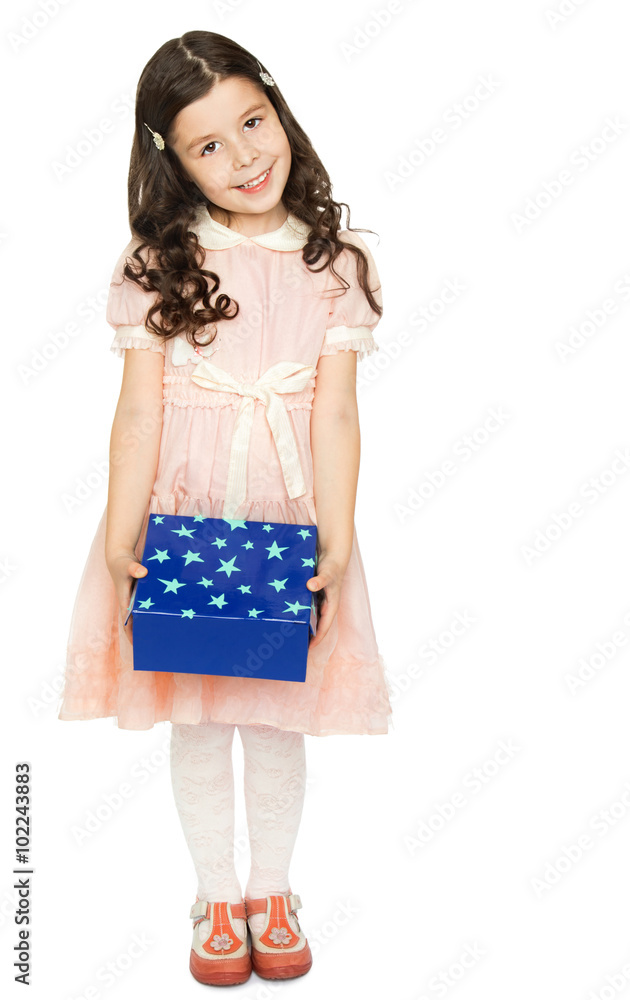 Cute little girl with long dark curly hair , dressed in a pink dress . The girl is holding in front of a blue box - Isolated on white background Cute little girl with long dark curly hair , dressed in a pink dress . The girl is holding in front of a blue box - Isolated on white background