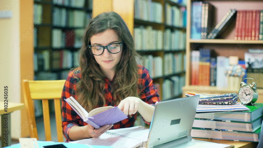 Girl sitting in the library and finish reading book
Girl sitting in the library and finish reading book
