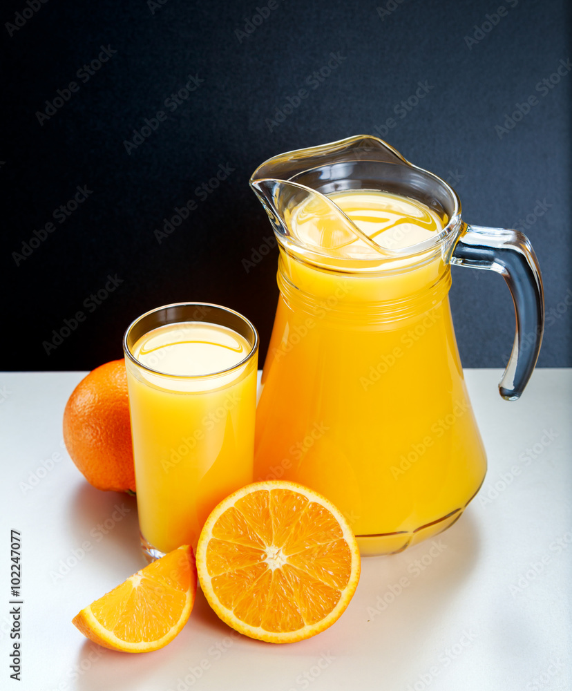 Glass and pitcher of fresh orange juice Glass and pitcher of fresh orange juice