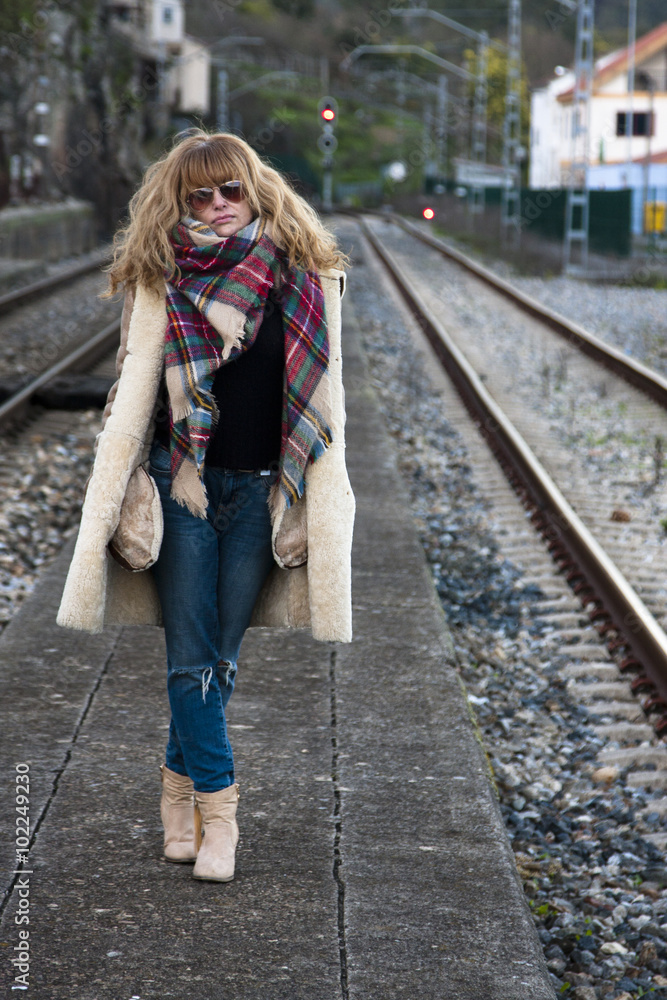 Young adult woman in casual fashion on train tracks Young adult woman in casual fashion on train tracks