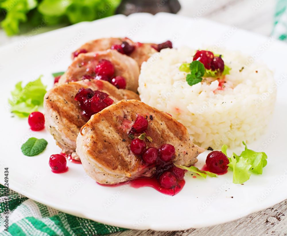Pork medallions steak with cranberry sauce and a side dish of rice Pork medallions steak with cranberry sauce and a side dish of rice