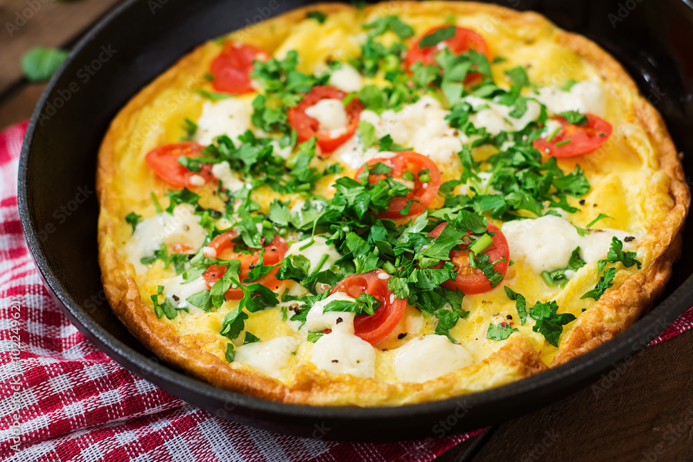 Omelet with tomatoes, parsley and feta cheese in pan Omelet with tomatoes, parsley and feta cheese in pan