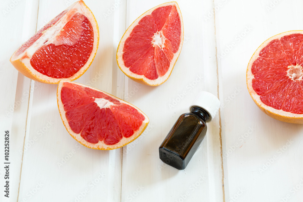 Essential oil in glass bottle with fresh, juicy grapefruit. Spa concept. Essential oil in glass bottle with fresh, juicy grapefruit. Spa concept.
