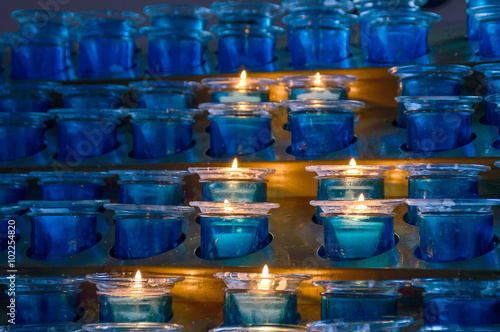Dark artistic blue glass votive candles with selective focus and photo