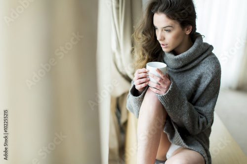 Pretty young woman with cup...