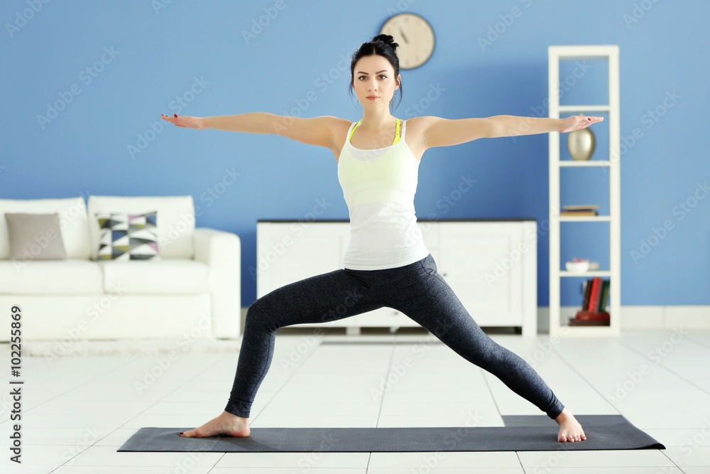 Fototapeta premium Health concept. Young attractive woman does yoga exercise in the room