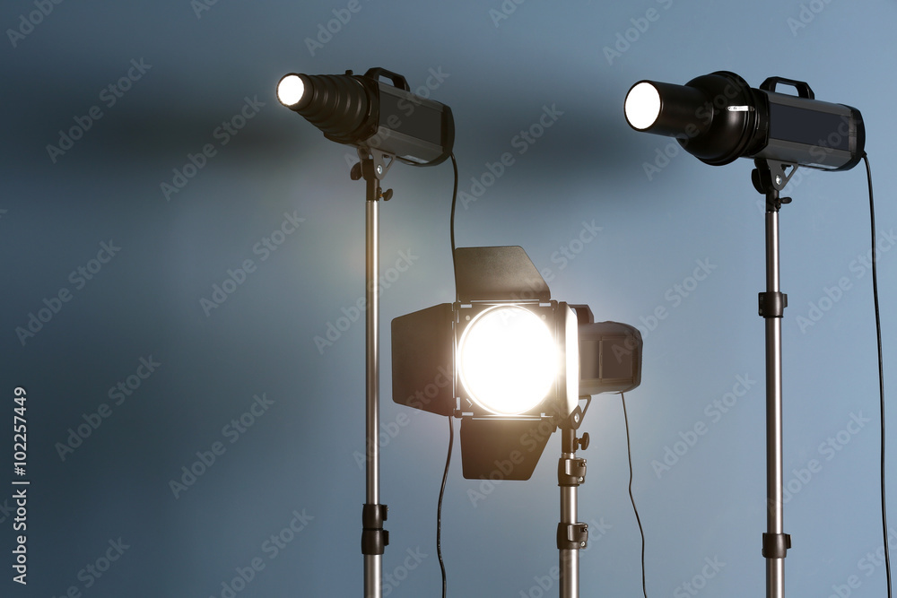 Studio light flashes on light blue wall background Studio light flashes on light blue wall background