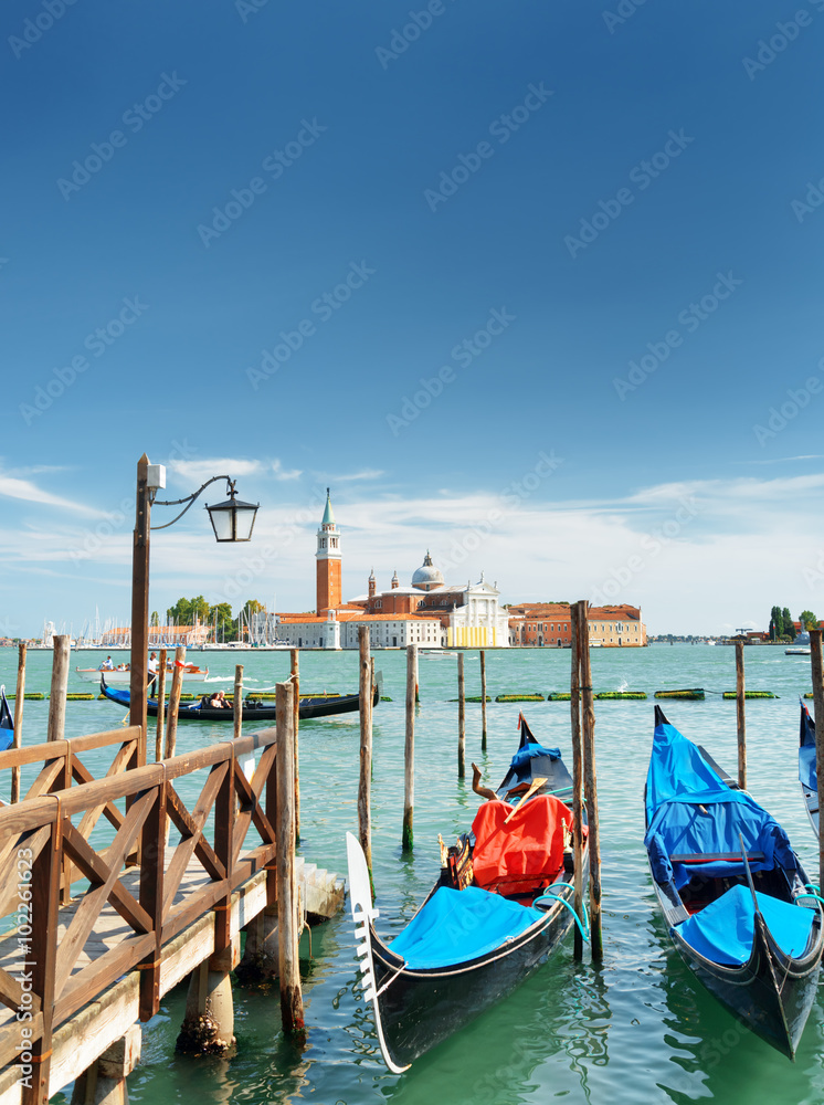 Gondolas parked at pier beside the Riva degli Schiavoni, Venice