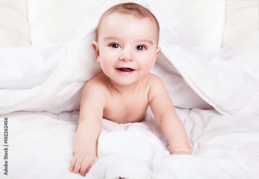 Cute and funny little baby smiling under white blanket. Copy spa Cute and funny little baby smiling under white blanket. Copy spa