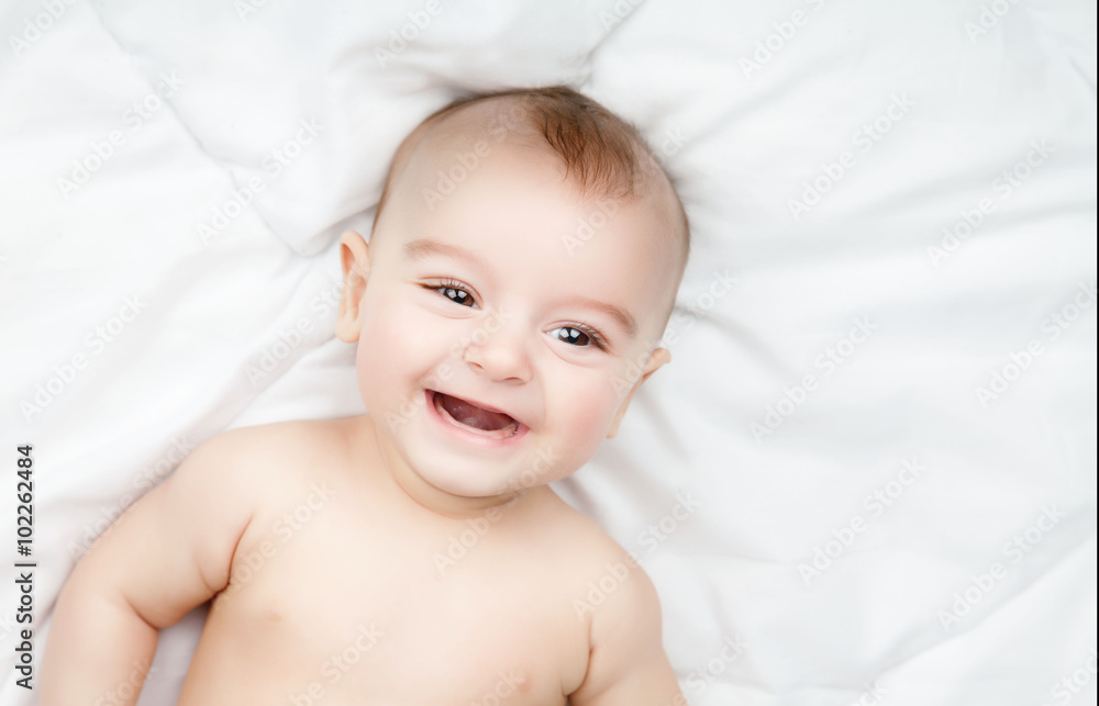 Cute and funny little baby smiling over white blanket. Copy spac Cute and funny little baby smiling over white blanket. Copy spac