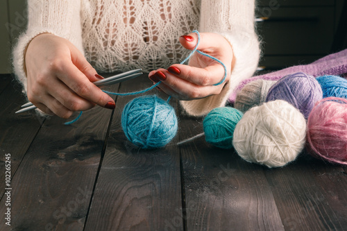 woman is knitting on a kitchen table