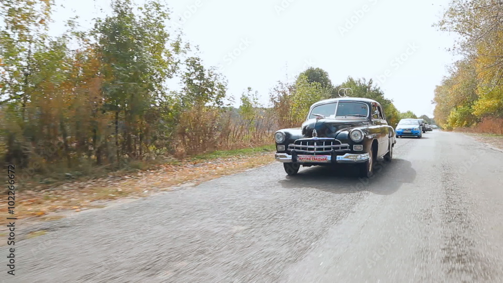 Marriage, wedding procession. Wedding old car on the autumn road 