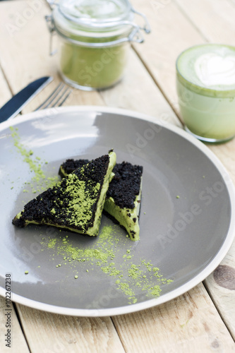 Cup of Matcha Green Tea in woman hand and Cake and ice cream 