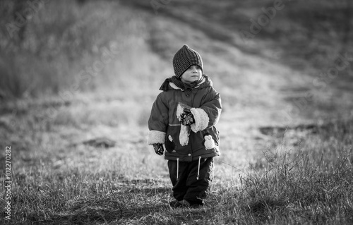 Young happy boy playing outdoor. Black and white photo.